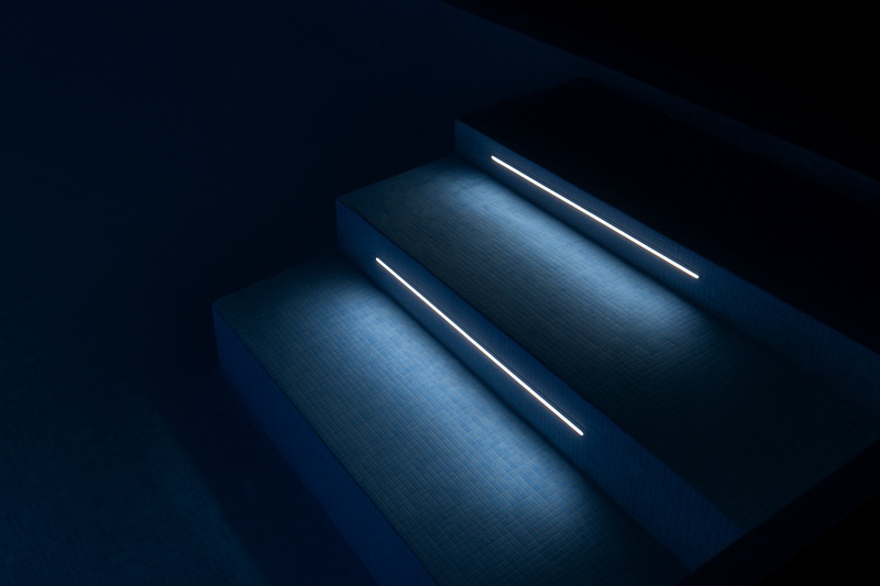 The serene underwater glow of an IP68 LED strip illuminating the steps of a swimming pool at night, with crystal clear water and a flawless line of light.