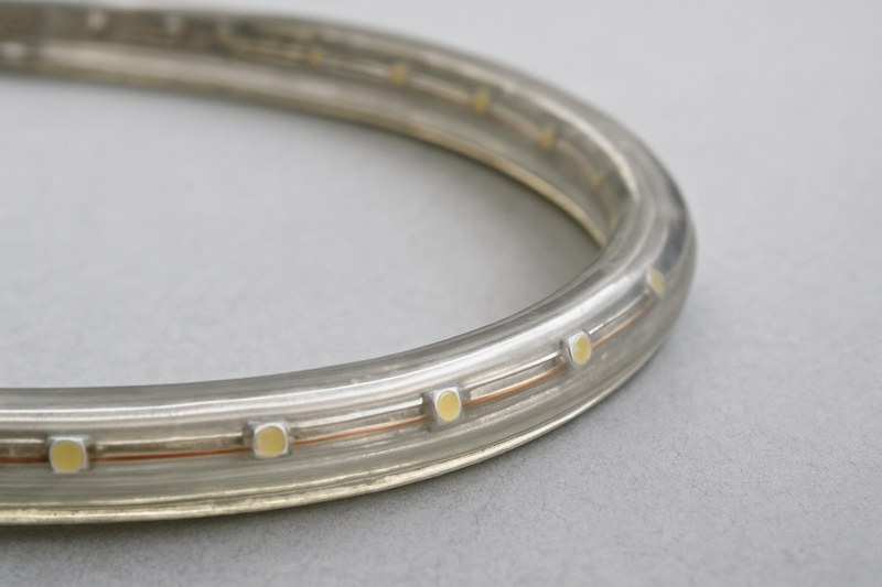 A photo showing a classic LED rope light, emphasizing its round shape, the visible gaps between the individual LEDs inside the tube, and its overall bulky look.