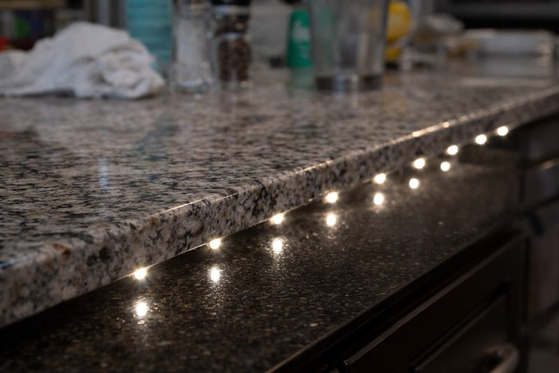 Photo: A granite countertop with a low-density strip reflecting distinct points of light, looking cluttered and cheap.
